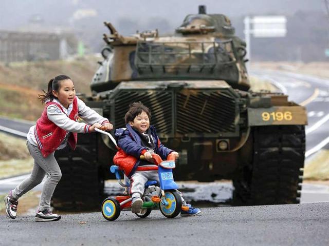 Children play in front of a tank on the island of Baengnyeong, which lies on the South Korean side of the Northern Limit Line (NLL), in the Yellow Sea. (Reuters)