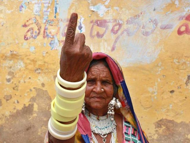 A tribal woman displays the indelible ink mark on her finger after casting her vote at a polling station on the outskirts of Hyderabad. (AP Photo)
