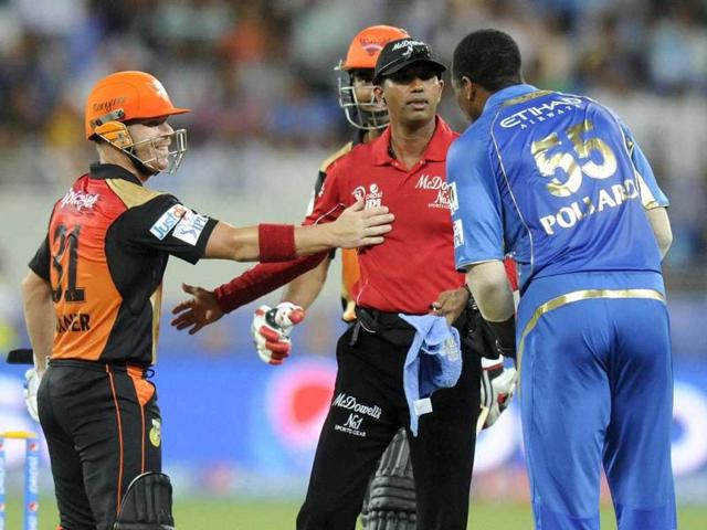 David Warner of Sunrisers Hyderabad and Kieron Pollard of Mumbai Indians check on umpire Dharmasena after the latter was hit by a ball during their IPL 7 match in Dubai. (PTI Photo)