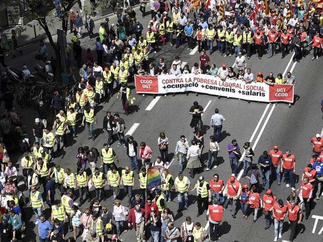 Demonstrators hold a placard reading "Against the social and labour poverty. Employment. Agreements. Wages" during the May Day rally in Barcelona (AFP photo)