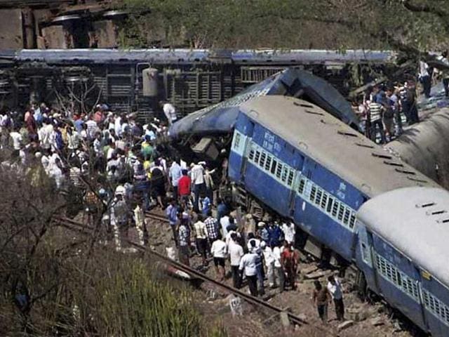 People gather around a passenger train that derailed near Roha station, south of Mumbai, India. (AP Photo)