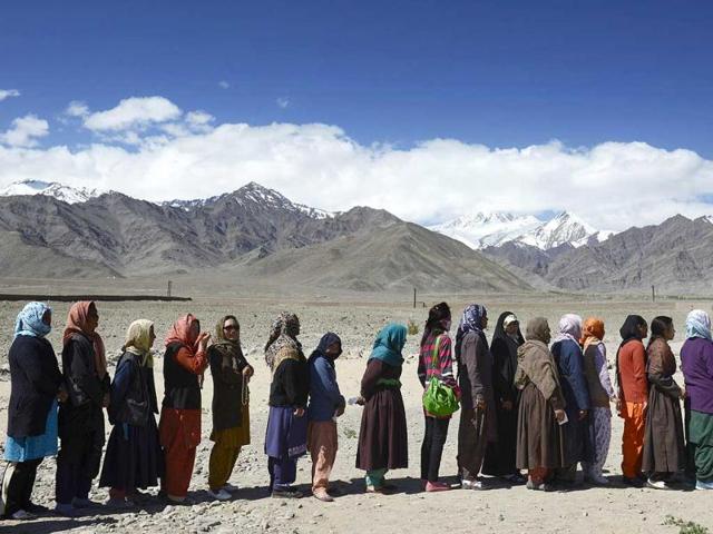People line up to vote outside a small rural school in Shushot Yongma, a small enclave on the Indus river valley near the northern city of Leh, against the backdrop of the Ladakh mountain range. (AFP Photo)