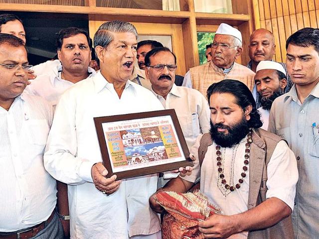 Chief-minister-Harish-Rawat-receives-a-portrait-of-Kedarnath-shrine-at-his-residence-in-Dehradun-on-Saturday-Rishi-Ballabh-HT-Photo Chief-minister-Harish-Rawat-receives-a-portrait-of-Kedarnath-shrine-at-his-residence-in-Dehradun-on-Saturday-Rishi-Ballabh-HT-Photo
