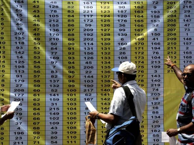 Polling officials check a displayed list to identify their designated counters at an election material distribution center ahead of the final phase of voting of the Lok Sabha elections in Kolkata. (AP Photo)