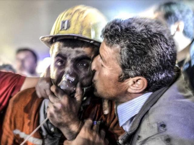 A man kisses his son, rescued from a Turkish mine after an explosion in a coal mine in Manisa. (AFP Photo)