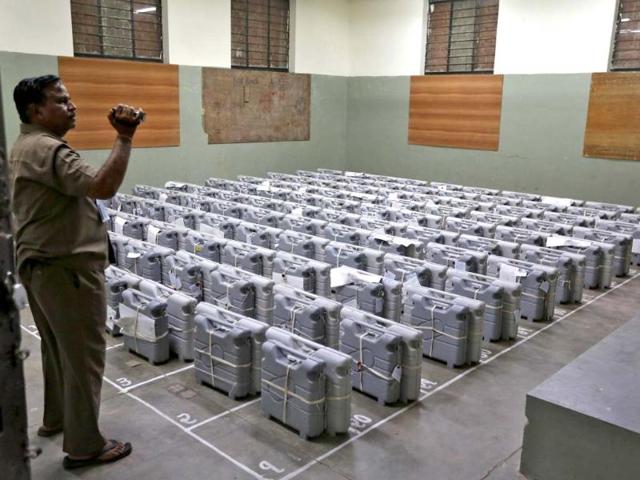 An official films electronic voting machines (EVM) inside a strongroom before the start of vote counting in Ahmedabad. (Reuters Photo)