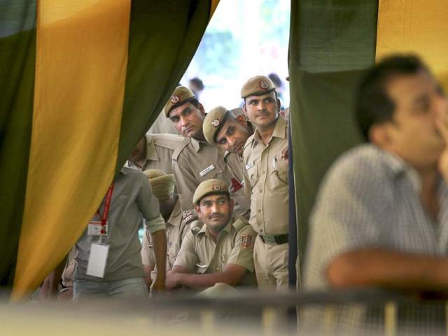 Policemen on duty watch election results on television at a counting station in New Delhi. (AP Photo)