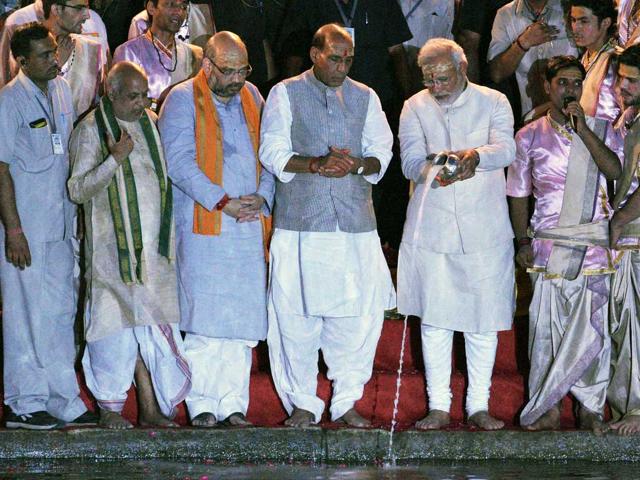 PM-designate Narendra Modi performs Ganga aarti as BJP president Rajnath Singh and senior leader Amit Shah look on, in Varanasi. (AFP Photo)