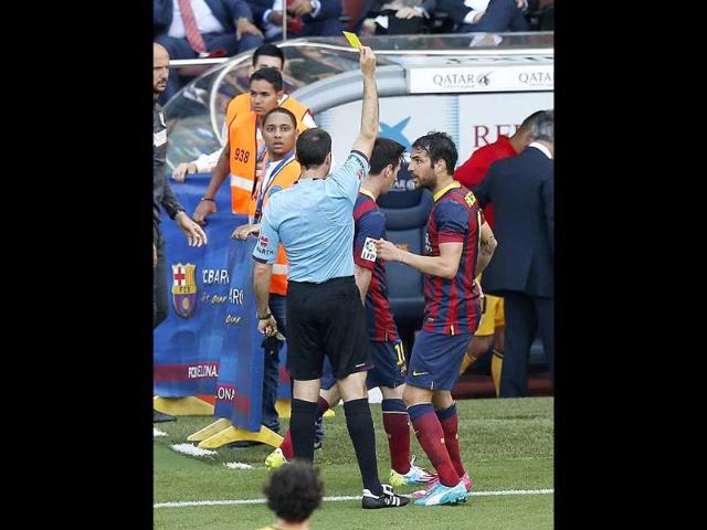 Referee Antonio Miguel Mateu (L) shows the yellow card to Barcelona's Lionel Messi near Cesc Fabregas (R) during their La Liga match against Atletico Madrid at Nou Camp stadium in Barcelona. (Reuters Photo) Referee Antonio Miguel Mateu (L) shows the yellow card to Barcelona's Lionel Messi near Cesc Fabregas (R) during their La Liga match against Atletico Madrid at Nou Camp stadium in Barcelona. (Reuters Photo)