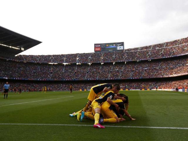 Atletico Madrid's Diego Godin (obscured) is congratulated by teammates after scoring against Barcelona during their La Liga match at Camp Nou stadium in Barcelona. (Reuters Photo) Atletico Madrid's Diego Godin (obscured) is congratulated by teammates after scoring against Barcelona during their La Liga match at Camp Nou stadium in Barcelona. (Reuters Photo)