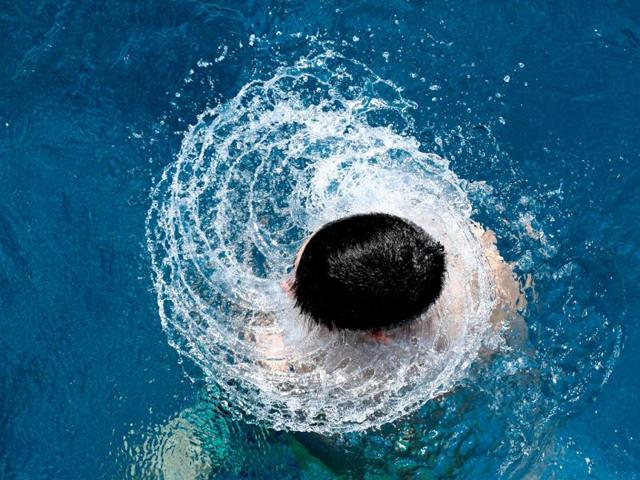 A boy dives out of the water at the Olympic open air public pool in Berlin, Germany. (AP Photo)