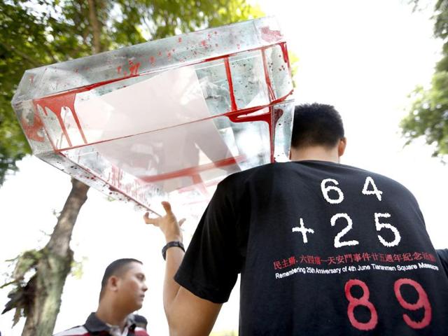 A protester carries a model of tank during a protest in front of the Chinese Embassy in Kuala Lumpur, Malaysia. A group of protesters staged a rally to mark the 25th anniversary of the Chinese military crackdown on the pro-democracy movement in Beijing's Tiananmen Square. The numbers in the shirt stands for "64 as June 4, and 25 as the 25th anniversary." (AP Photo)