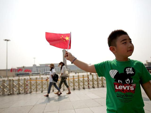 A boy poses with a Chinese national flag in front of Tiananmen Square in Beijing. From keeping foreign reporters off Beijing's Tiananmen Square to widespread censorship of the Internet, China marked 25 years since the bloody suppression of pro-democracy protests under a cloak of security. (Reuters)