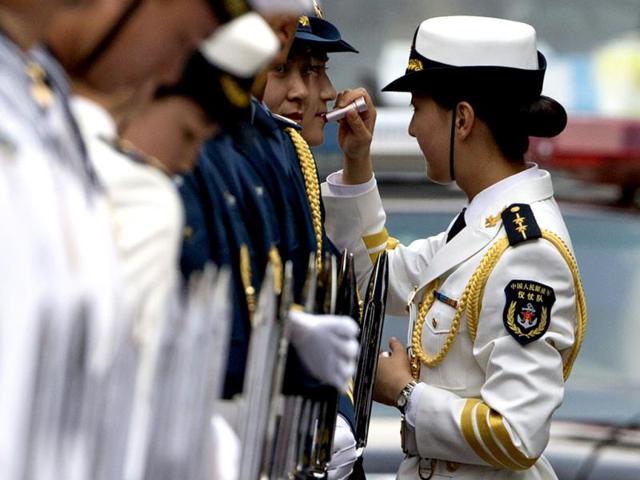 A female officer of the Chinese People's Liberation Army (PLA) Guard of Honor helps another guard to put on lipstick during their preparations for the welcome ceremony of Bangladesh Prime Minister Sheikh Hasina (not in photo) at the Great Hall of the People in Beijing. (EPA Photo)