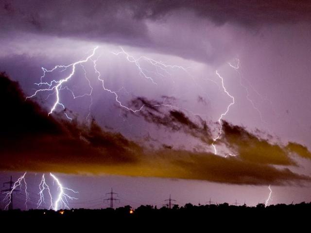 Lightning bolts illuminate the sky as they strike near high voltage power lines in Sehnde, near Hanover, northern Germany. (EPA)