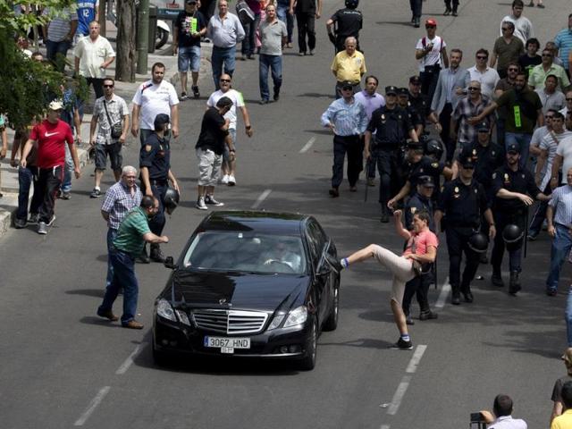 A demonstrator kicks a car during a 24 hour taxi strike and protest in Madrid. (AP Photo) 