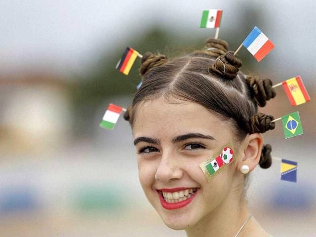 A-football-fan-dons-miniature-national-flags-representing-Italy-Germany-Mexico-the-Netherlands-Spain-Brazil-and-Bosnia-in-her-hair-AP-Photo A-football-fan-dons-miniature-national-flags-representing-Italy-Germany-Mexico-the-Netherlands-Spain-Brazil-and-Bosnia-in-her-hair-AP-Photo