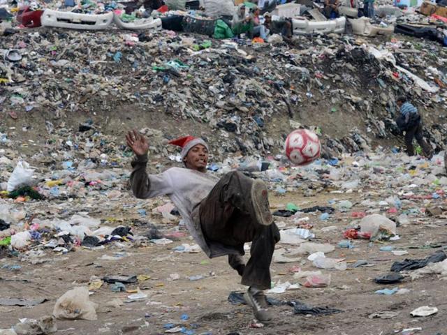Honduras, Tegucigalpa: A young scavenger plays with a football in the municipal incinerator grounds in the outskirts of Tegucigalpa. (AFP PHOTO)