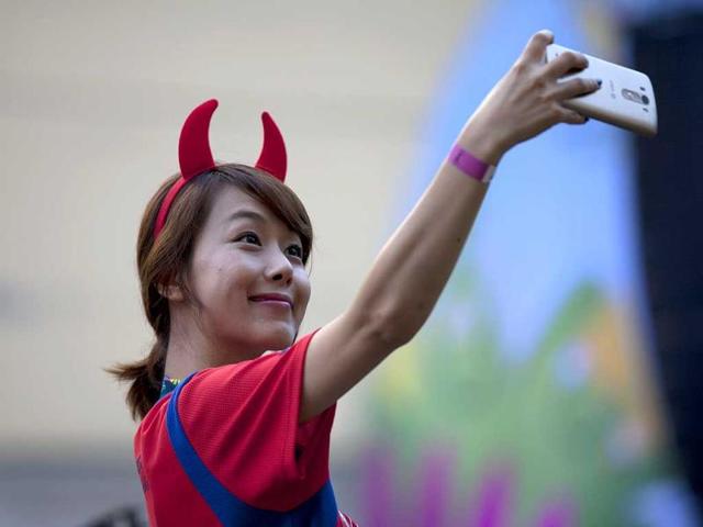 A South Korean journalist takes a selfie while covering the match between Mexico and Brazil during the 2014 World Cup in Sao Paulo, Brazil. (AP Photo) 