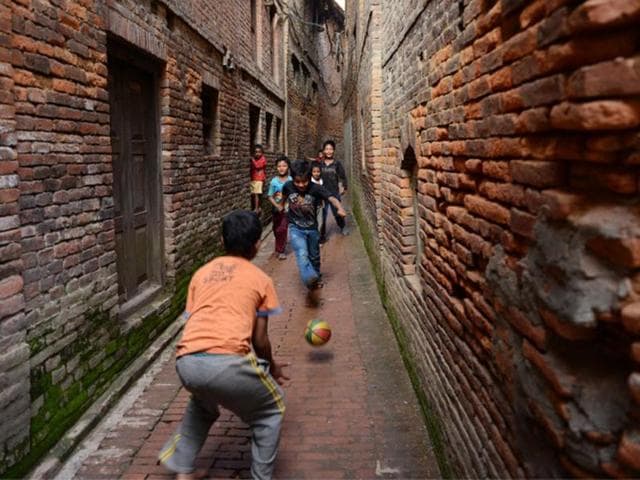 Nepal, Bhaktapur: Nepalese children play football in a passageway near the Durbar Square. (AFP PHOTO)
