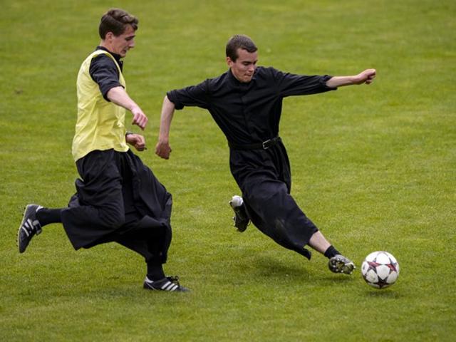Switzerland, Riddes: Seminarians of the International Seminary of Saint Pius X vie wearing their cassocks for the ball during a football game. After a whole week dedicated to prayer and study, priests and seminarians play during their Sunday afternoon dedicated to sport and relaxation. (AFP PHOTO)