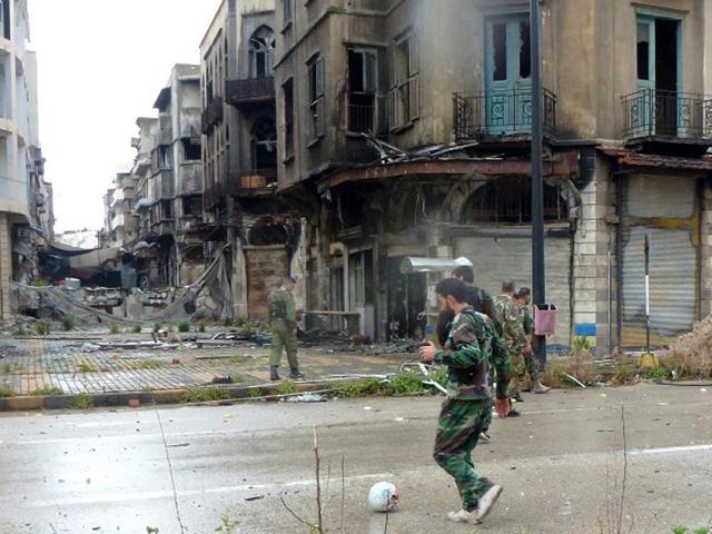 Syria, Homs: Syrian government forces play football on a deserted street in the old city of Homs after they regained control of rebel-controlled areas. (AFP PHOTO)