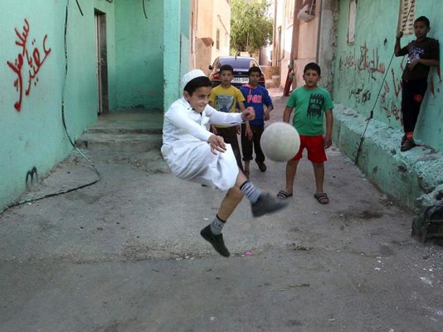 Al-Fawar: Palestinian youths play football on a street in the refugee camp of Al-Fawar near the West Bank town of Hebron. (AFP PHOTO)