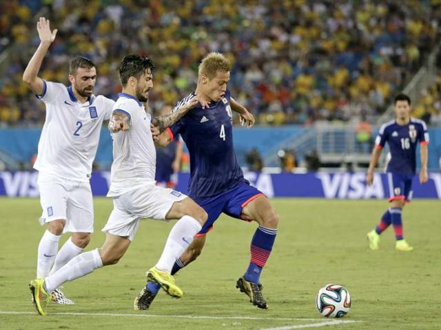 Japan-s-Keisuke-Honda-R-takes-on-the-Greek-defence-during-the-Group-C-World-Cup-match-between-Japan-and-Greece-at-the-Arena-das-Dunas-in-Natal-Brazil-AP-Photo Japan-s-Keisuke-Honda-R-takes-on-the-Greek-defence-during-the-Group-C-World-Cup-match-between-Japan-and-Greece-at-the-Arena-das-Dunas-in-Natal-Brazil-AP-Photo
