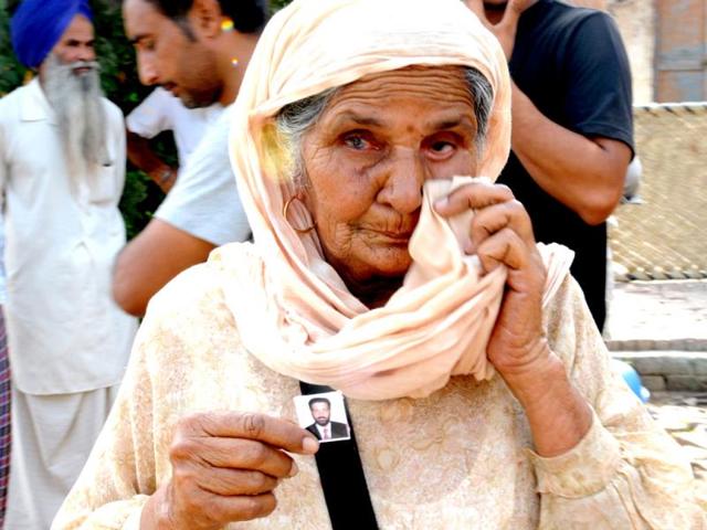 A Grandmother Beant Kaur of Sahib Singh, who were taken hostage in Iraq, showing photograph of his grandson at Khatuli village in Patiala District. (HT Photo)