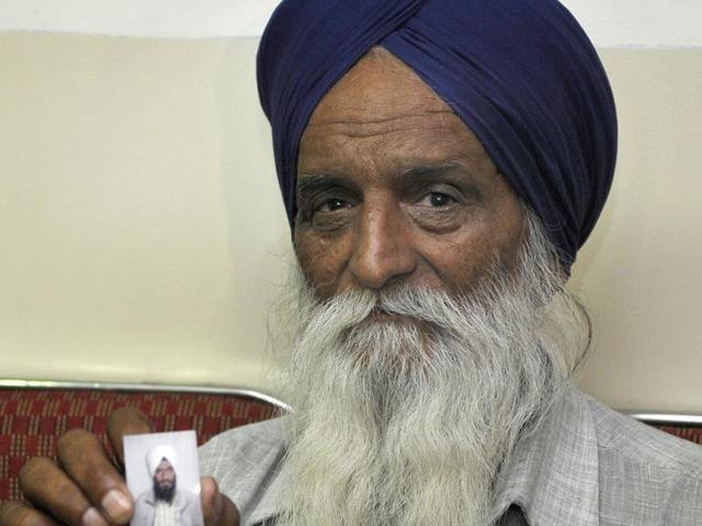 Family member of one of the Indians who has reportedly been abducted in Iraq, holding a photograph of his kin during a visit to Rakab Ganj Gurudwara, in New Delhi. (Sonu Mehta/ HT Photo)