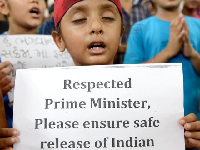 Indian children and elders from the Sikh community offer special prayers known as 'Ardas' for the safe and early release of Indians kidnapped in Iraq, at the Gurudwara Gururamdas Society, Bapunagar in Ahmedabad. (AFP Photo)