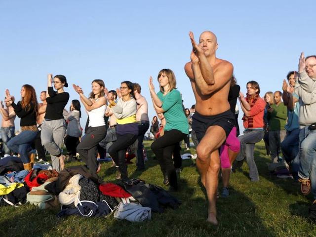 Revelers practice yoga at the Stonehenge. (AP photo)