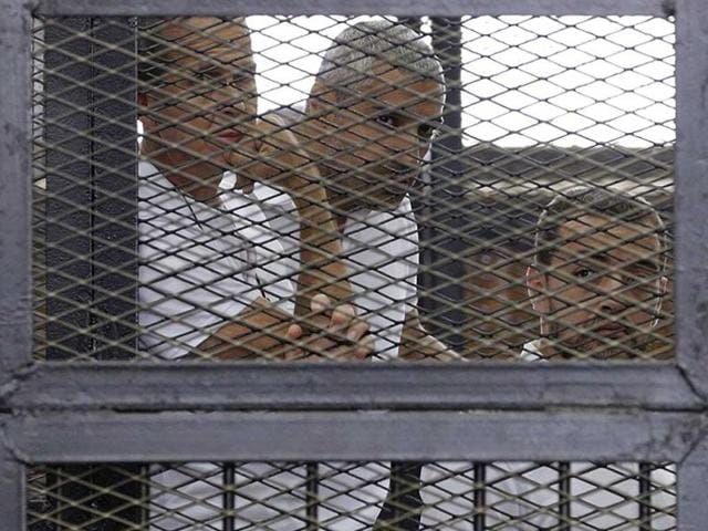 Al-Jazeera-journalists-L-R-Peter-Greste-Mohammed-Fahmy-and-Baher-Mohamed-stand-behind-bars-at-a-court-in-Cairo-in-this-June-1-2014-file-photograph-Reuters-Photo