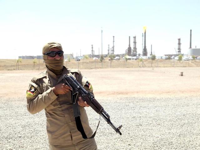 A member of Kurdish security forces takes up position with his weapon as he guards an oil refinery on the outskirts of Mosul. (Reuters photo)