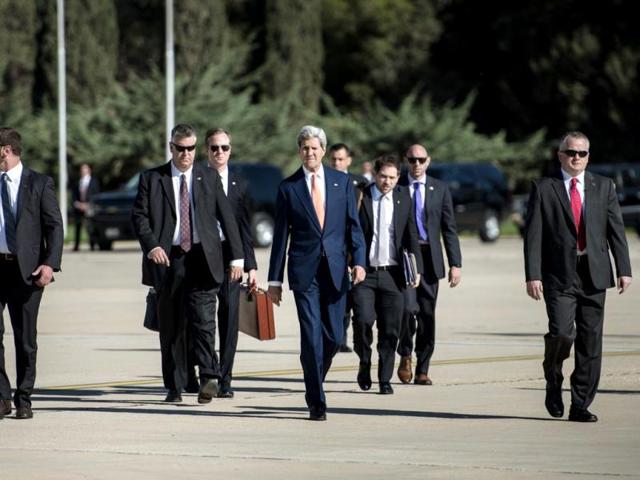 John Kerry walks with staff and bodyguards to the Iraq-bound plane. (AFP photo)