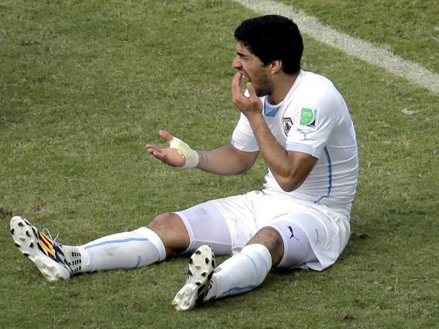 Uruguay-s-Luis-Suarez-holds-his-teeth-after-biting-Italy-s-Giorgio-Chiellini-s-shoulder-during-the-Group-D-World-Cup-match-between-Italy-and-Uruguay-at-the-Arena-das-Dunas-in-Natal-Brazil
