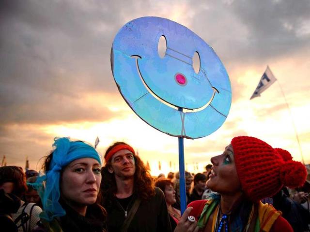 Revellers carry a smiley face sign through the crowds as the sun sets at the festival. (AFP photo)
