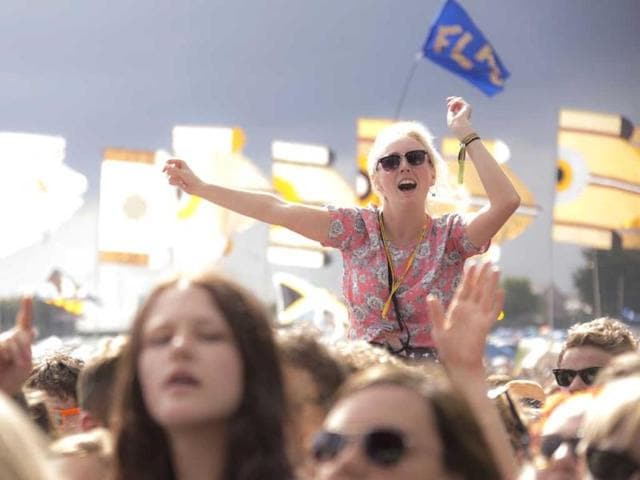 A festival goer gestures as she is lifted above the shoulders of the crowd while watching U.S band Haim perform on the Other stage at Glastonbury music festival. (AP photo)