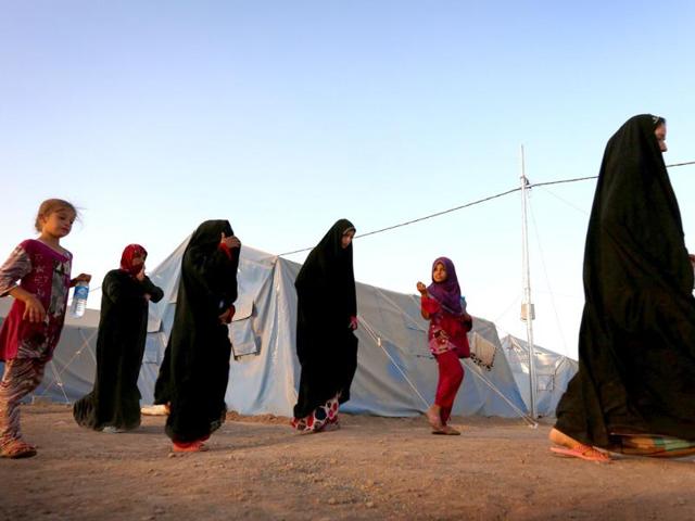 Displaced Iraqi woman walk at sunset past tents provided by the UN refugee agency at a temporary camp set up to shelter people fleeing violence in northern Iraq in Aski Kalak, 40 kms west of the Kurdish autonomous region's capital Arbil. Saudi Arabia pledged $500 million in humanitarian aid for Iraq to be disbursed through the United Nations to those in need regardless of sect or ethnicity, state media reported. (AFP photo)