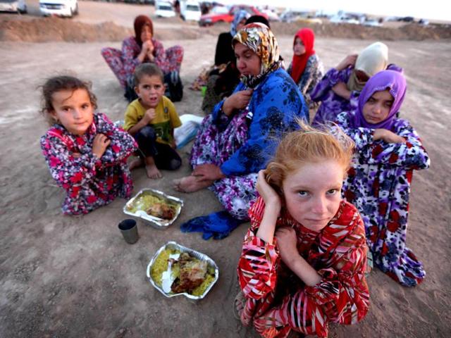 Iraqi families fleeing violence in the northern city of Tal Afar, arrive at the Kurdish checkpoint in Aski kalak, 40 km West of Arbil, in the autonomous Kurdistan region. (AFP photo)