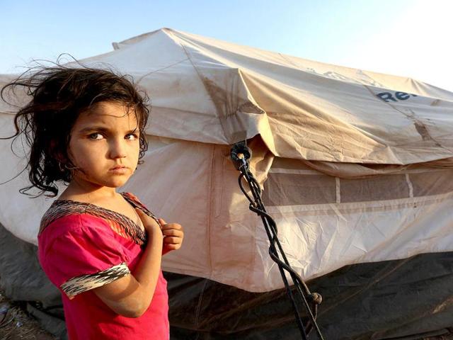 An Iraqi girl and her family fleeing violence in the northern city of Tal Afar, arrive at the Kurdish checkpoint in Aski kalak, 40 km West of Arbil, in the autonomous Kurdistan region. (AFP photo)