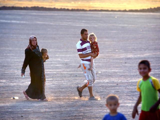 Iraqi families fleeing violence in the northern city of Tal Afar, arrive at the Kurdish checkpoint in Aski kalak, 40 km West of Arbil, in the autonomous Kurdistan region. (AFP photo)