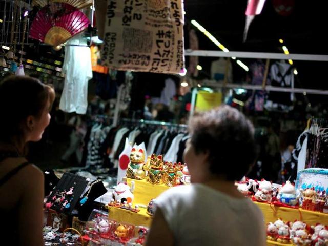 Women shop for portable "Better Fortune Cats", traditional cat statuettes which are thought to bring prosperity to their owners, during the 15th edition of the "Japan Expo" exhibition, Villepinte (AP Photo)
