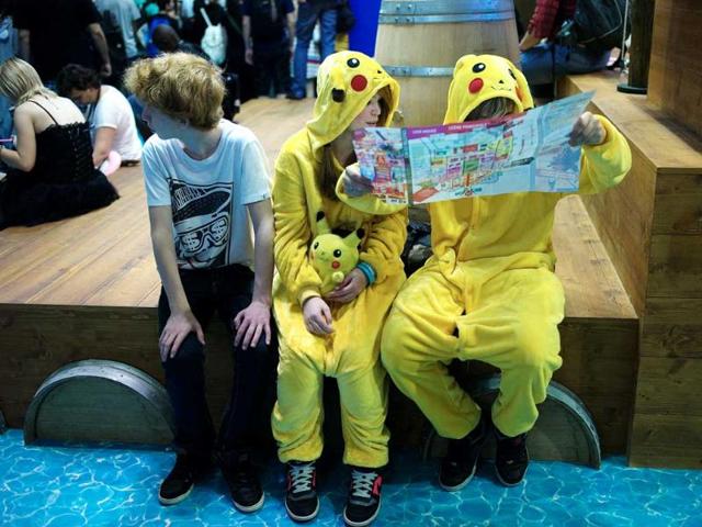 People dressed like Pikachu, a character from Japanese animation, 'Pokemon', look a map as they attend the 15th edition of the "Japan Expo" exhibition, Villepinte (AP Photo)