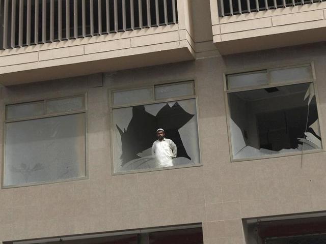 A man looks out from a broken glass window after an explosion near a mosque in Karachi. (Reuters)