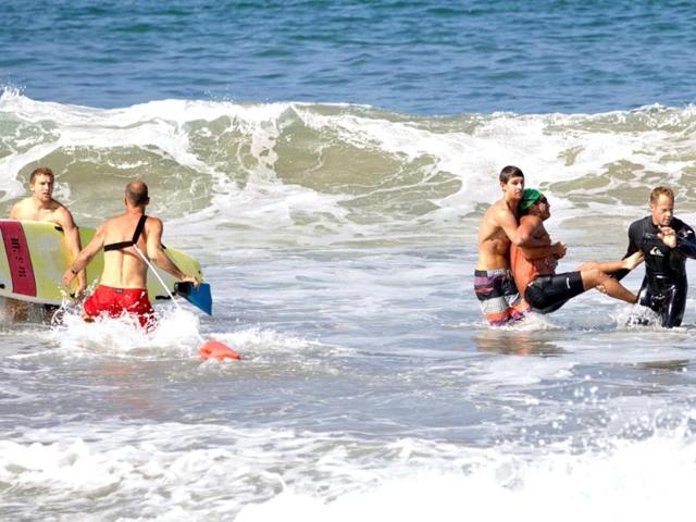 Two-men-carry-a-swimmer-second-from-right-after-he-was-bitten-by-a-great-white-shark-as-lifeguards-close-in-at-left-in-the-ocean-off-Southern-California-s-Manhattan-Beach-AP-photo-goofyfootphotography-com-Laura-Joyce Two-men-carry-a-swimmer-second-from-right-after-he-was-bitten-by-a-great-white-shark-as-lifeguards-close-in-at-left-in-the-ocean-off-Southern-California-s-Manhattan-Beach-AP-photo-goofyfootphotography-com-Laura-Joyce