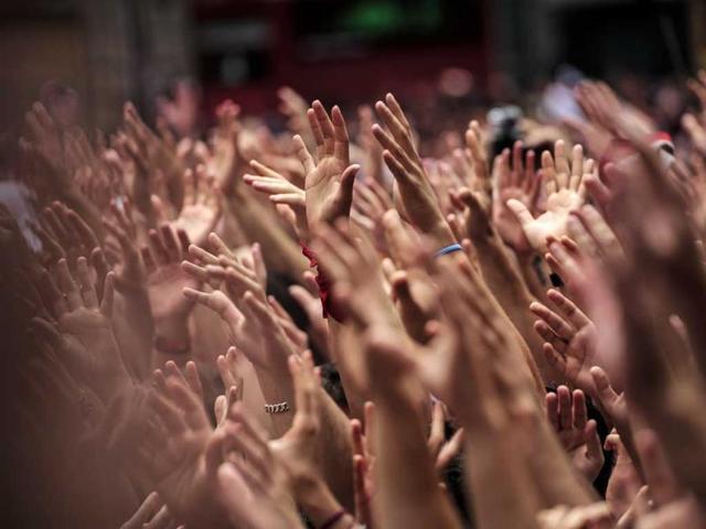 Revelers hold up their hands during the launch of the 'Chupinazo' rocket, to celebrate the official opening of the 2014 San Fermin fiestas, in Pamplona, Spain. (AP Photo)