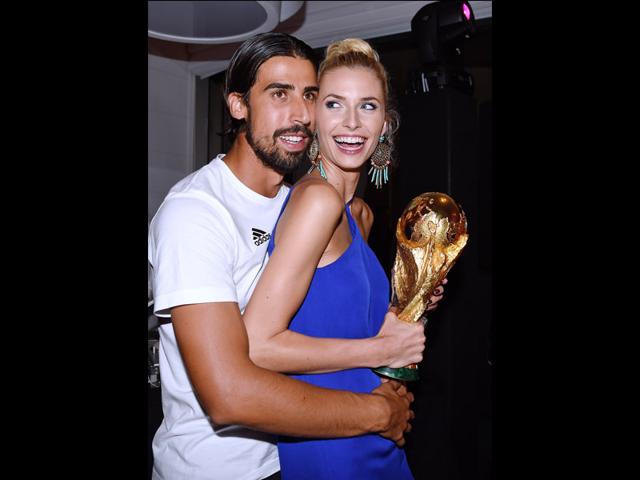 Germany's Sami Khedira and his girlfriend Lena Gercke holding the trophy as they attend the party of the German soccer federation after Germany beat Argentina 1-0 in the soccer World Cup final on July 13, 2014. (AP Photo/DFB, Markus Gilliar)