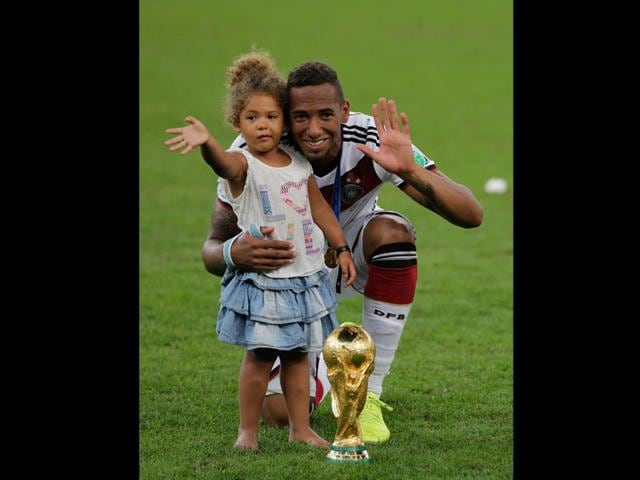 Germany's Jerome Boateng poses for a photo with his daughter after the World Cup final soccer match between Germany and Argentina at the Maracana Stadium in Rio de Janeiro on July 13, 2014. (AP Photo/Matthias Schrader)