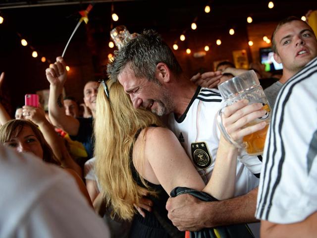 Simon Vogt, of Germany celebrates with his girlfriend, Leslie Wilber after the World Cup soccer final in Brazil between Germany and Argentina, at Wolff's Biergarten in Albany, N.Y., on July 13, 2014. (AP Photo/Patrick Dodson)